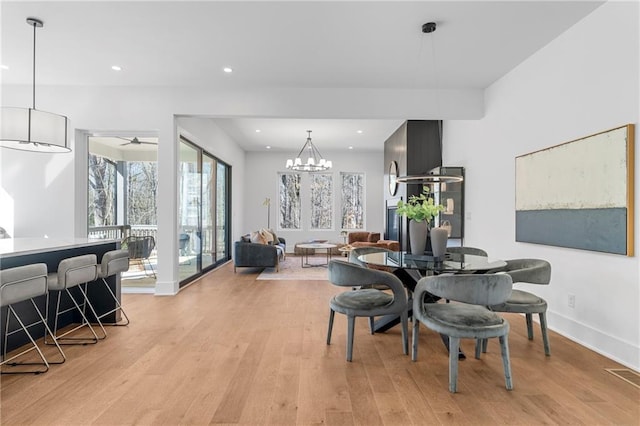dining area featuring light wood finished floors, a chandelier, recessed lighting, and baseboards