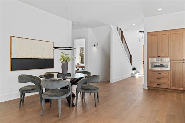dining room featuring stairs, light wood finished floors, baseboards, and recessed lighting