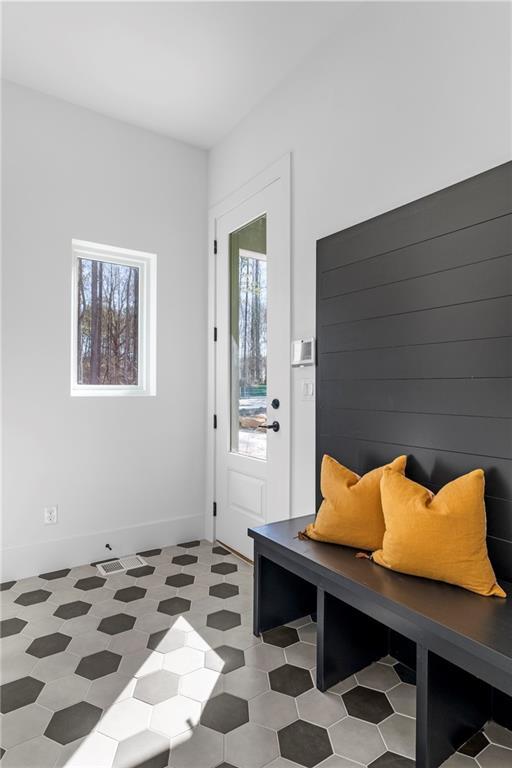 mudroom with light floors and baseboards