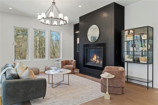 living area featuring light wood-style floors, recessed lighting, and a chandelier