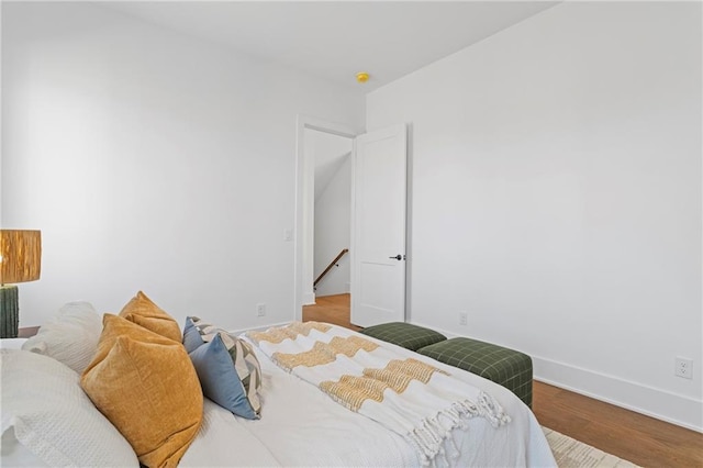 bedroom with baseboards and wood finished floors