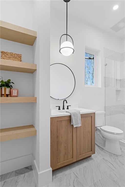 bathroom featuring marble finish flooring, a stall shower, toilet, vanity, and baseboards