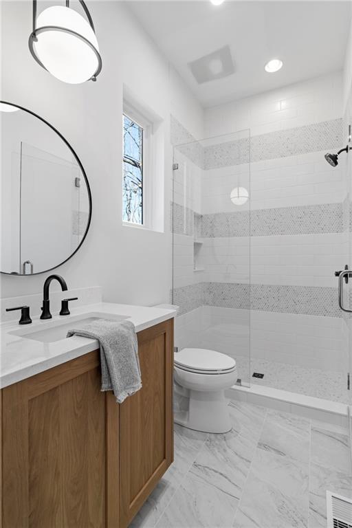 full bath featuring toilet, vanity, a shower stall, recessed lighting, and marble finish floors
