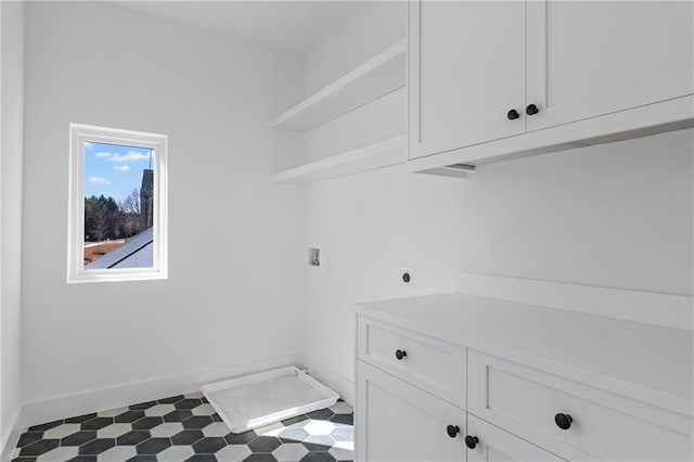 washroom featuring cabinet space, hookup for a washing machine, electric dryer hookup, and baseboards