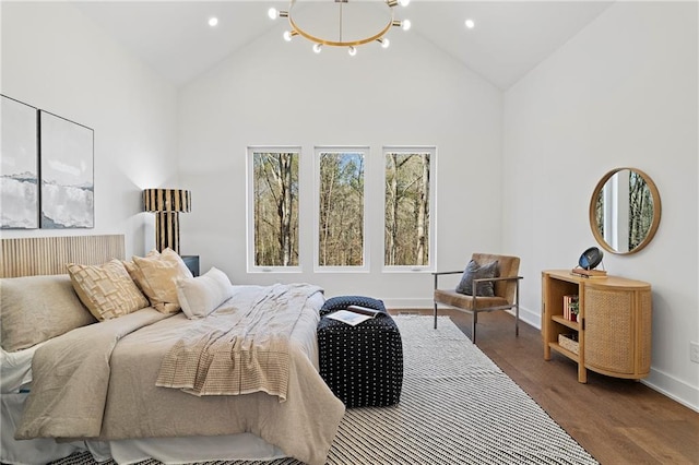 bedroom with high vaulted ceiling, a chandelier, wood finished floors, baseboards, and recessed lighting
