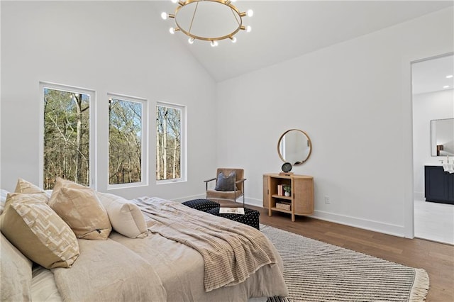 bedroom featuring a chandelier, high vaulted ceiling, multiple windows, wood finished floors, and baseboards