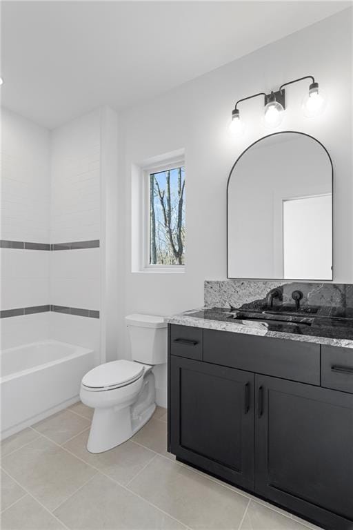 bathroom with toilet, vanity, tile patterned flooring, and a bathtub
