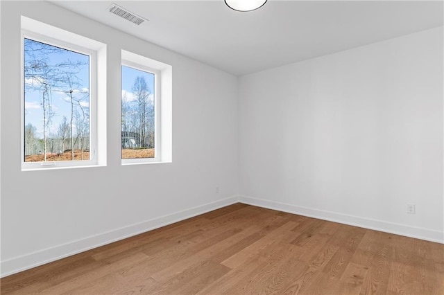 empty room with light wood-type flooring and baseboards