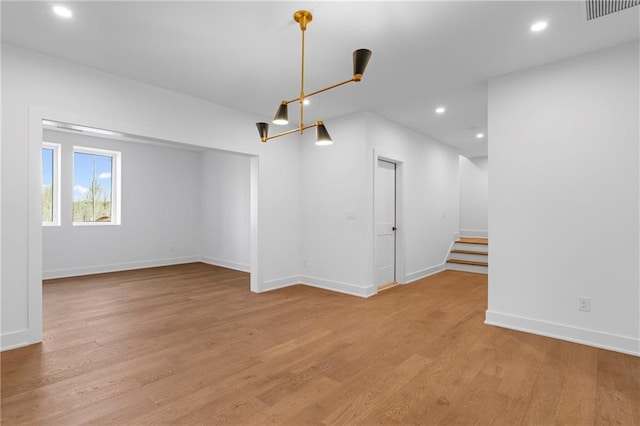spare room with light wood-style floors, stairs, baseboards, and recessed lighting