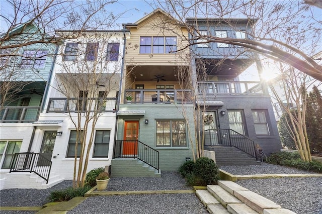 multi unit property featuring brick siding, a ceiling fan, and a balcony