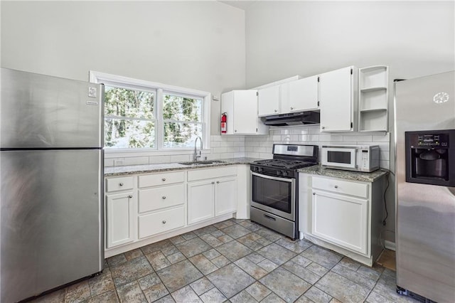 kitchen with open shelves, appliances with stainless steel finishes, white cabinetry, a sink, and under cabinet range hood