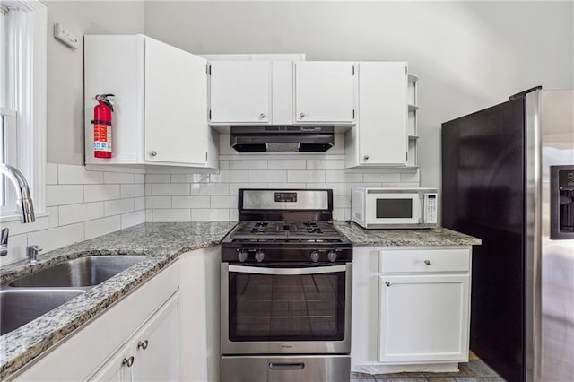 kitchen featuring stainless steel appliances, a sink, white cabinetry, ventilation hood, and tasteful backsplash