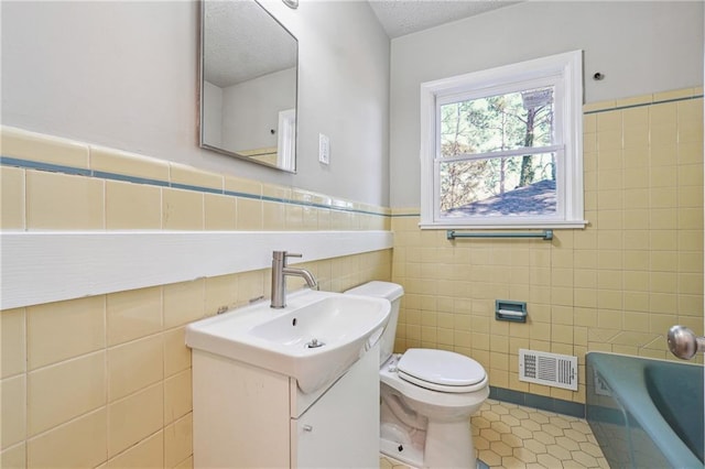 full bathroom with visible vents, toilet, tile patterned floors, vanity, and a bath