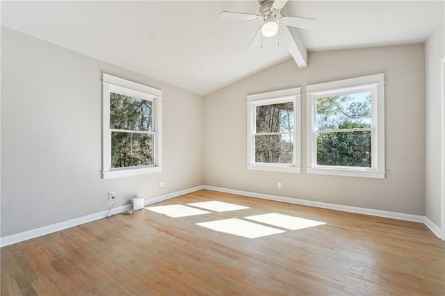 unfurnished room with vaulted ceiling with beams, light wood finished floors, plenty of natural light, and baseboards