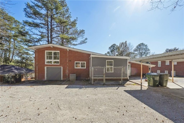 rear view of property with driveway and brick siding