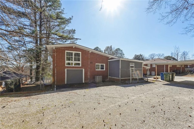 back of property featuring brick siding, central AC unit, and an outdoor structure