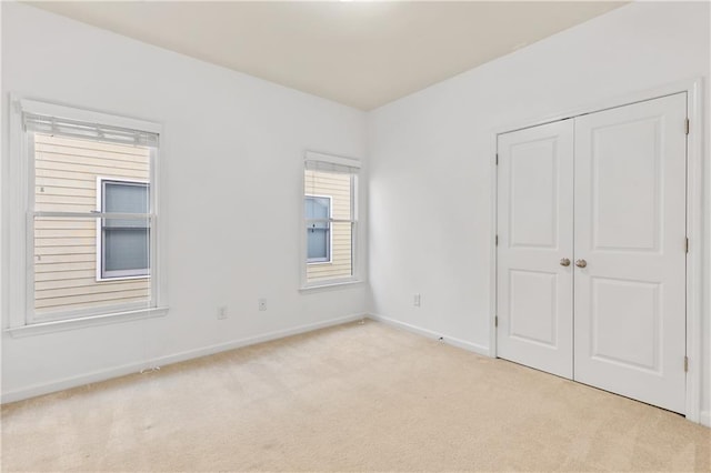 unfurnished bedroom with a closet, baseboards, and carpet flooring