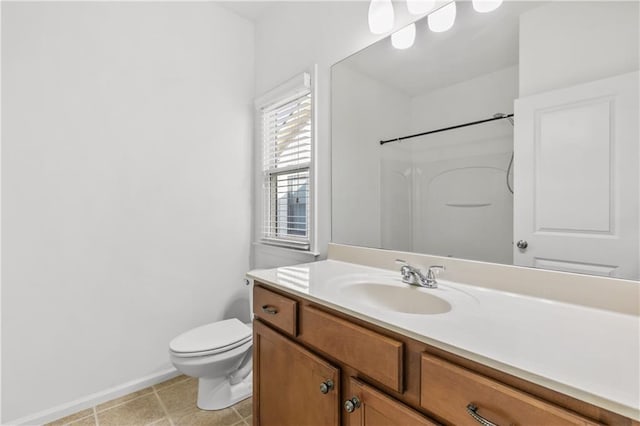 full bath featuring baseboards, vanity, toilet, and walk in shower