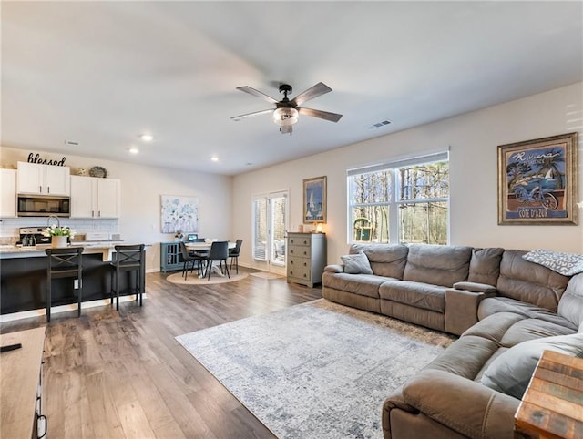 living room with ceiling fan and light hardwood / wood-style floors