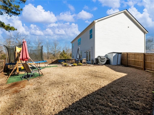 exterior space with a playground, a lawn, and a trampoline