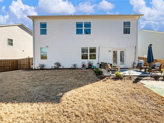 rear view of house featuring a lawn and a patio