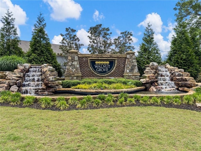 community / neighborhood sign featuring a lawn