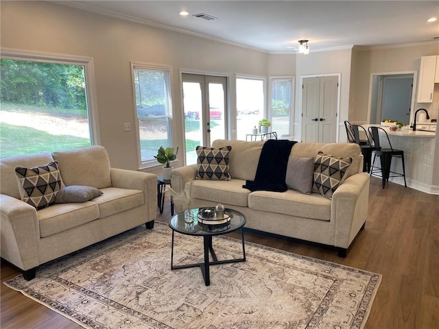living area featuring healthy amount of natural light, crown molding, dark wood-style floors, and recessed lighting