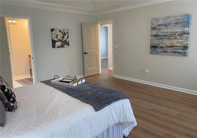 bedroom with wood finished floors, ornamental molding, and baseboards