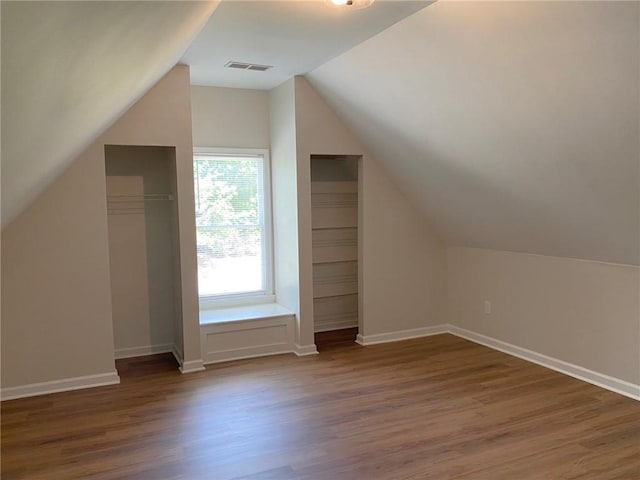 bonus room with lofted ceiling, wood finished floors, and baseboards