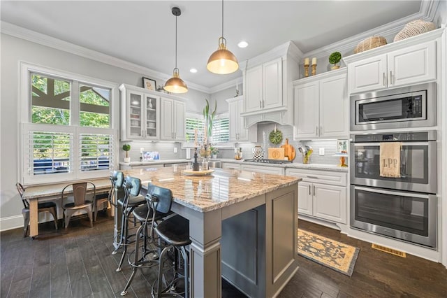 3111 Old Thompson Mill Rd, Buford, GA 30519 - kitchen featuring stainless steel appliances, white cabinetry, recessed lighting, dark wood finished floors, and a kitchen breakfast bar