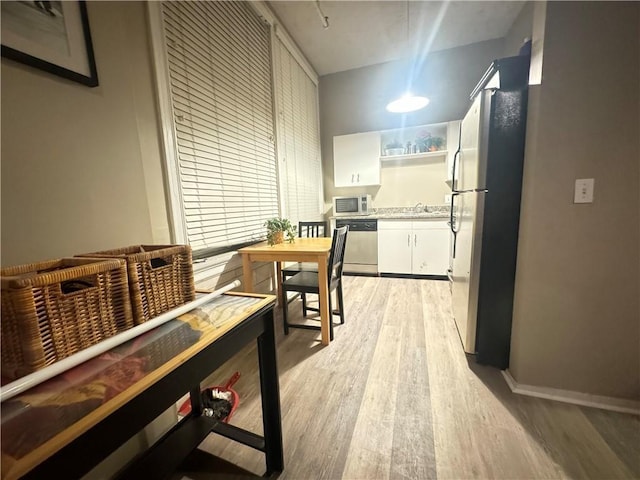 interior space with baseboards and light wood finished floors