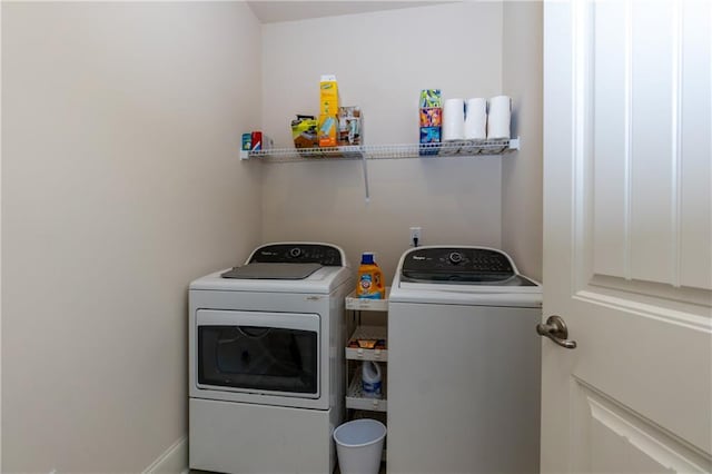 clothes washing area with washer and clothes dryer