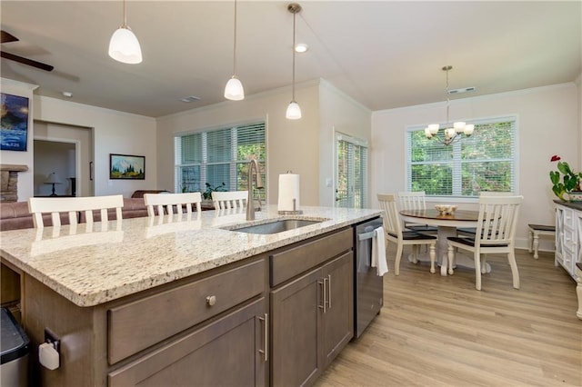 kitchen featuring a wealth of natural light, sink, decorative light fixtures, and light hardwood / wood-style floors