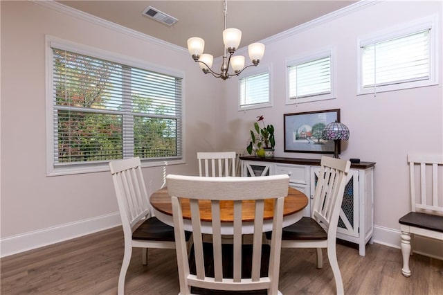 dining room with wood-type flooring, a chandelier, and crown molding