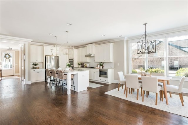 kitchen featuring a chandelier, stainless steel appliances, a kitchen island, and decorative light fixtures