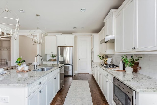 kitchen featuring white cabinets, decorative light fixtures, stainless steel appliances, an island with sink, and sink