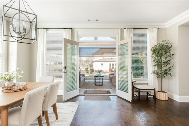 entryway with dark hardwood / wood-style flooring, ornamental molding, french doors, and an inviting chandelier