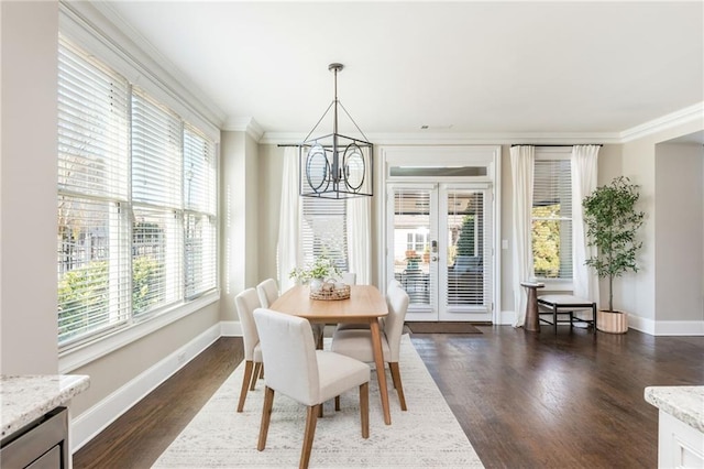 dining area featuring dark hardwood / wood-style flooring, ornamental molding, and an inviting chandelier