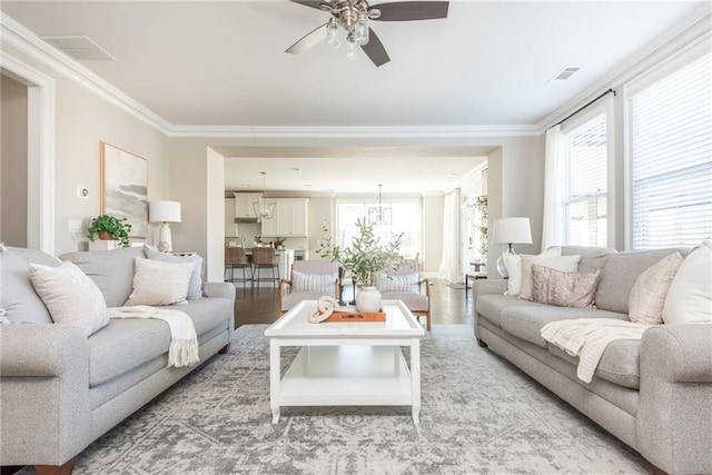 living room with light hardwood / wood-style flooring, ceiling fan, and ornamental molding