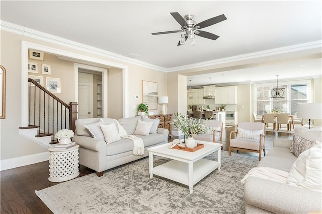 living room with ceiling fan with notable chandelier, wood-type flooring, and ornamental molding