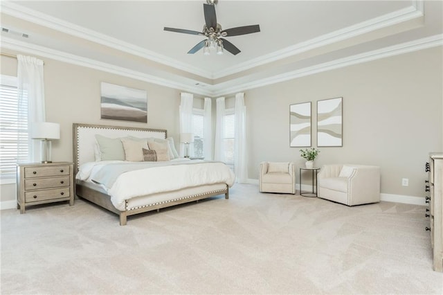 carpeted bedroom featuring ceiling fan, a tray ceiling, and crown molding