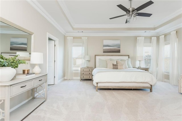 carpeted bedroom featuring ceiling fan, a raised ceiling, ornamental molding, and multiple windows