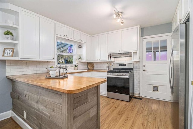 kitchen with stainless steel appliances, a peninsula, open shelves, and under cabinet range hood