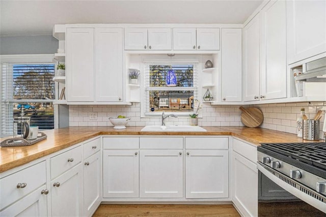 kitchen featuring open shelves, a sink, and white cabinets