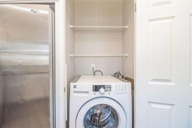 clothes washing area with laundry area, washer / dryer, and attic access