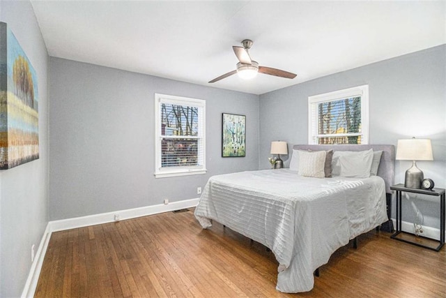 bedroom with visible vents, ceiling fan, baseboards, and wood finished floors