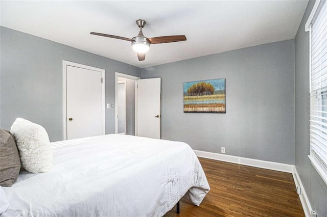 bedroom with a ceiling fan, dark wood finished floors, and baseboards