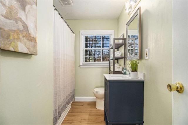 full bathroom featuring baseboards, visible vents, toilet, wood finished floors, and vanity