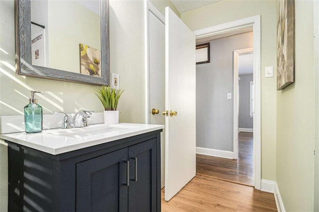 interior space featuring light wood finished floors, a sink, and baseboards