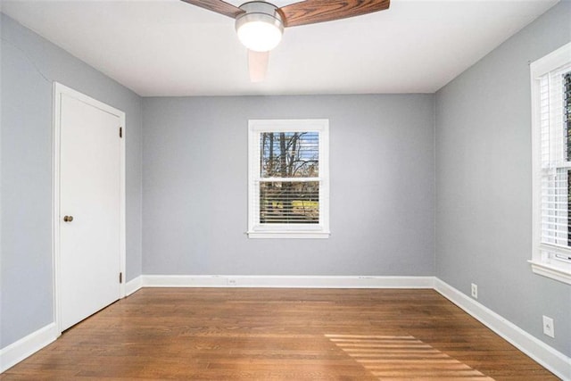 spare room featuring baseboards and wood finished floors